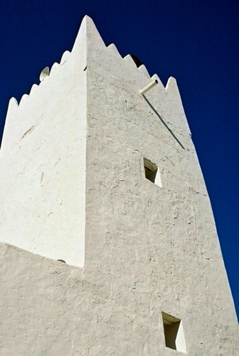 Immagine con torre, finestre, cielo, bianco, blu, merli, alta, bianca