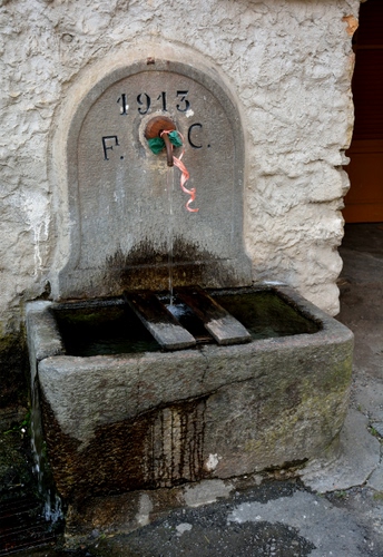 Immagine con acqua, fontana, data, pietra, rubinetto, nastro, muro, iniziali, numeri