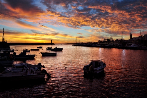 Immagine con barche, tramonto, mare, nuvole, porto, cielo, acqua, controluce
