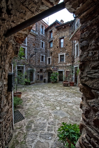 Immagine con finestre, borgo, vasi, piante, porte, arco, pietra, piazza, case, verde, pietre, cortile, scorcio, selciato, mattoni, paese