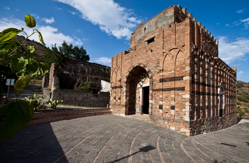 Immagine con chiesa, nuvole, arco, foglie, cielo, mattoni, porta, archi, piazza