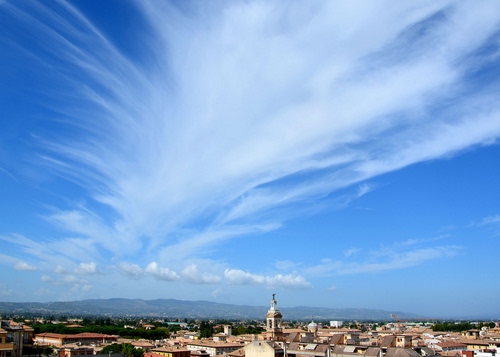 Immagine con campanile, cielo, nuvole, tetti, azzurro, città, case, alberi, bianco, colline, panorama, nuvola, paese, montagne