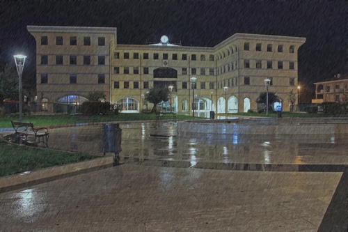 Immagine con piazza, pioggia, lampione, notte, palazzo, luci, bagnato, lampioni, panchina, riflessi