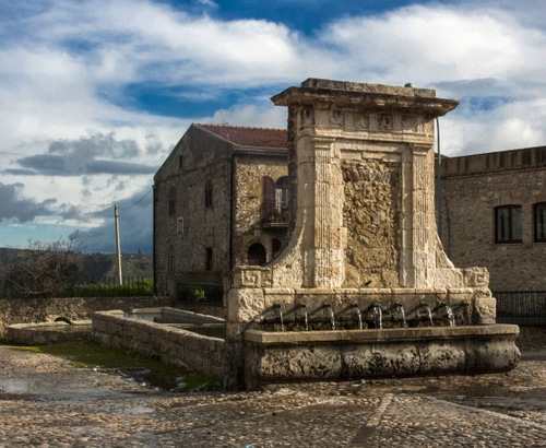 Immagine con fontana, cielo, acqua, nuvole, lavatoio, casa, finestre, fontane, zampilli, pietra, alberi, piazza, fontanelle, vasca